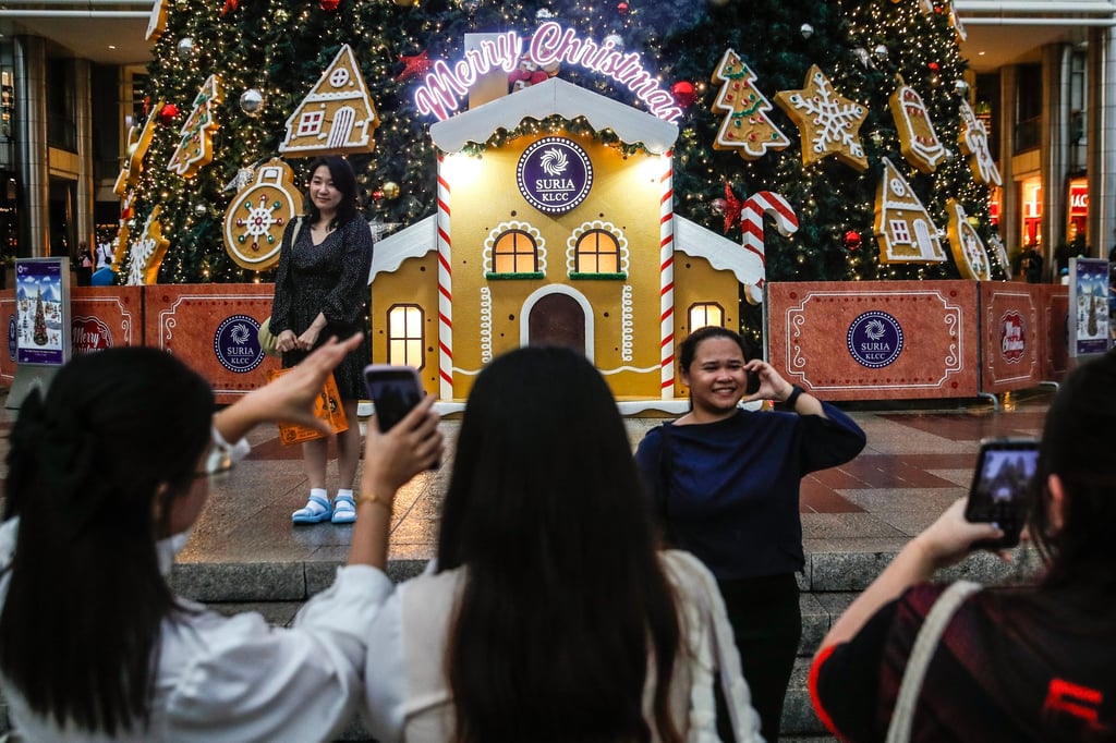 Women take pictures in front of the tallest Christmas tree replica in Malaysia at the Petronas Twin Towers in Kuala Lumpur. Cultural flare-ups in Malaysia were once a seasonal affair, but they’ve become more frequent in recent years amid a rise in religious conservatism. Photo: EPA-EFE
