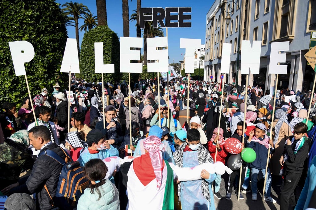 Protesters hold placards and Palestinian flags during a march in Rabat, Morocco on Sunday. Photo: AFP