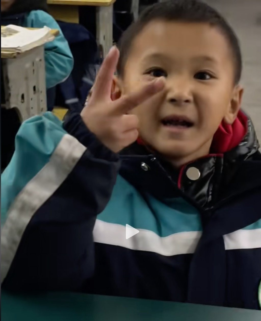 The happy youngster uses a hand signal to let his school friends know that his father had bought him not one, but two, gifts. Photo: Douyin The happy youngster uses a hand signal to let his school friends know that his father had bought him not one, but two, gifts. Photo: Douyin