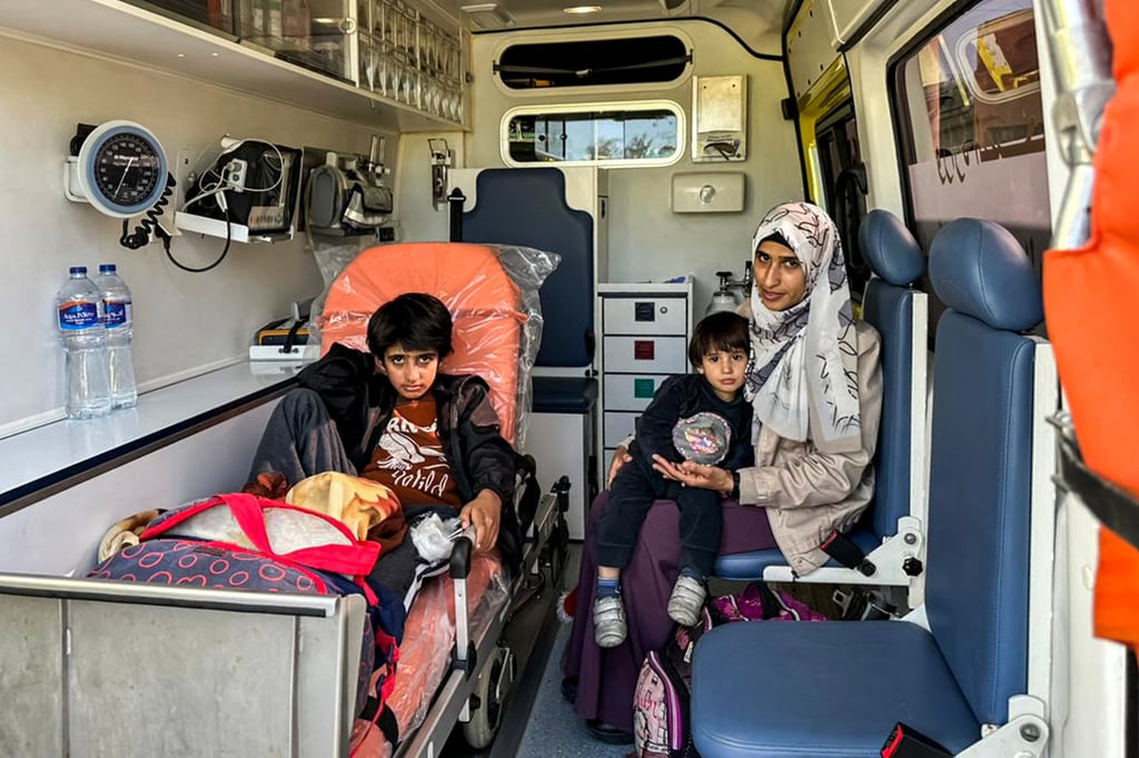 A woman sits with her children in an ambulance after being evacuated with other Palestinians from the Gaza Strip at the Rafah border crossing in northeastern Egypt on December 30, 2023. Photo: AFP