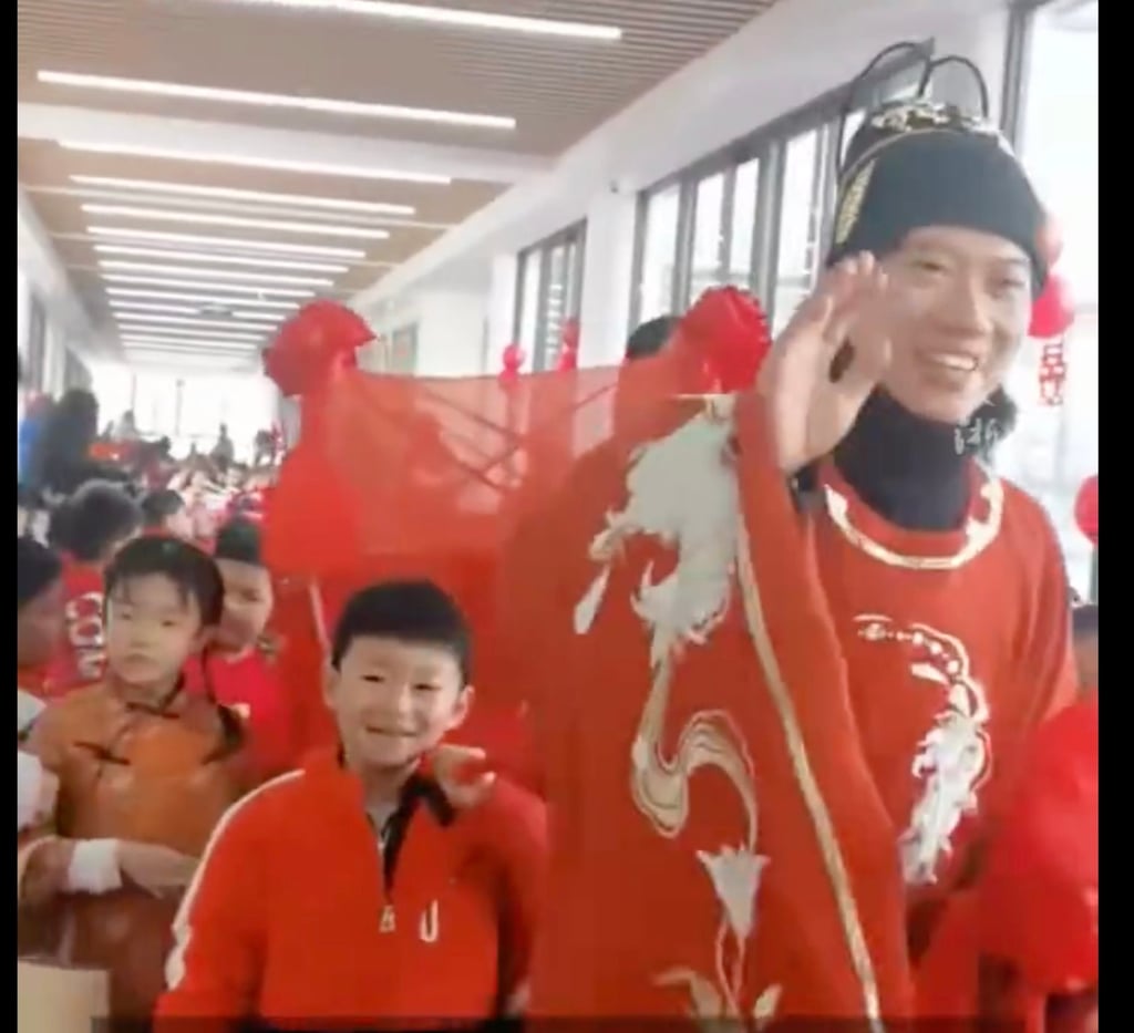 The groom waves happily as his young students walk in procession with him during the ceremony. Photo: Weibo