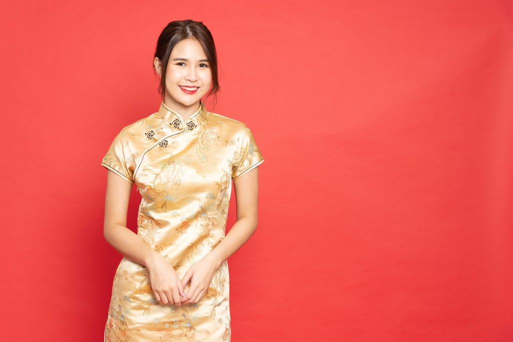 A woman wears a golden cheongsam. Wearing yellow or gold at Chinese New Year will, it is said, bring you fortune. Make sure your outfit has some red, too – it could be underwear. Photo: Shutterstock Images
