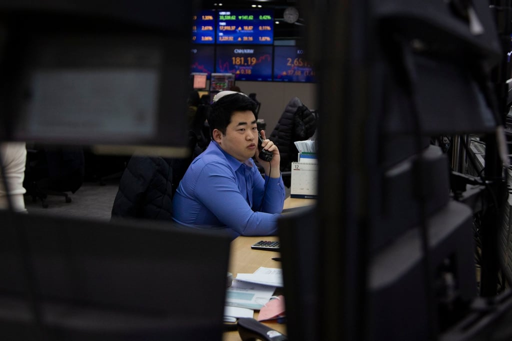 A trader works in front of a bank of monitors at a bank in Seoul on December 28. The lengthening of won trading hours is part of South Korea’s bid to improve access and boost the case for recognition as a developed market. Photo: EPA-EFE