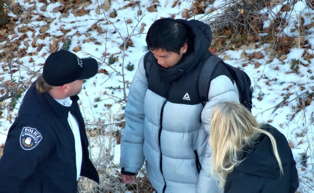 Authorities speaking to Kai Zhuang near the site where he was found. Photo: Riverdale Police Department via AFP