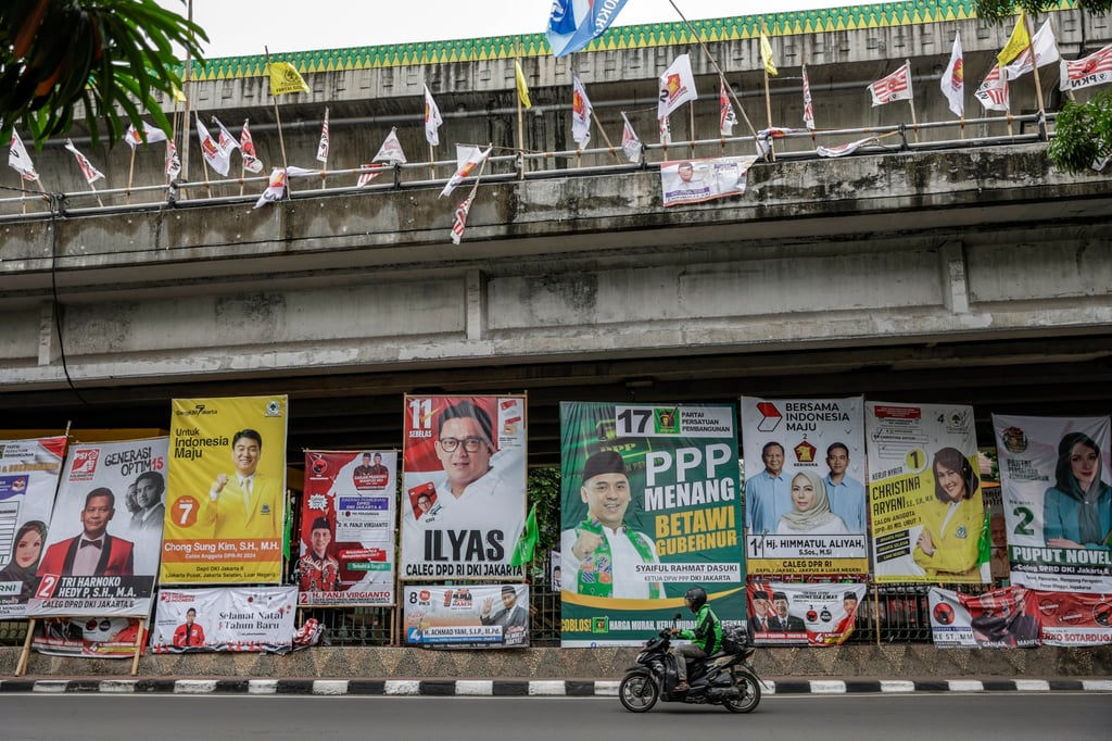 A motorist rides past banners with pictures of campaigning parliamentary candidates along the street in Jakarta. Photo: EPA-EFE
