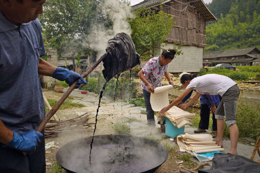 Dong minority artisans dye fabric with indigo created from tree bark. They say the dye is harmless and can be washed into the river. Photo: Justin Jin