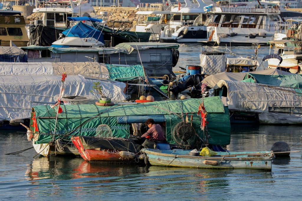 A boat woman goes about her daily duties at the Causeway Bay Typhoon Shelter. Luxury yachts are moored in the background. Photo: Antony Dickson A boat woman goes about her daily duties at the Causeway Bay Typhoon Shelter. Luxury yachts are moored in the background. Photo: Antony Dickson