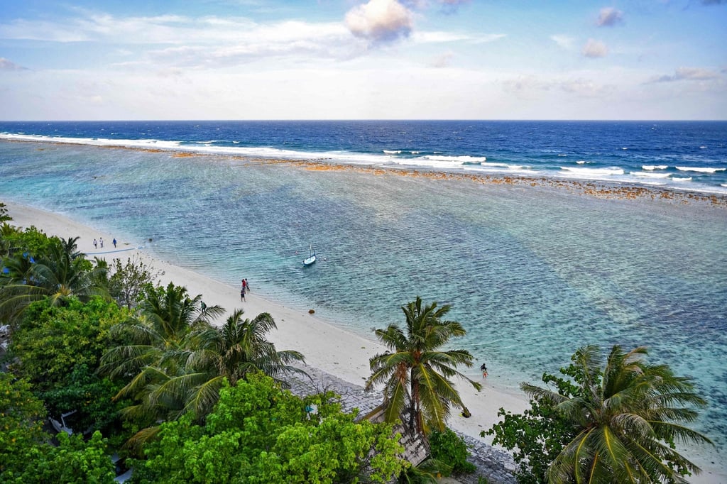 People walk on a beach in Hulhumale, Maldives, on December 26. The Indian Ocean nation’s 1,192 islands are dotted with luxury resorts. Photo: AFP