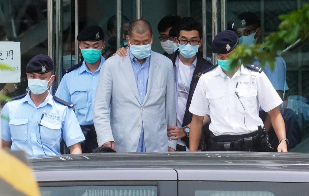 Jimmy Lai (centre) is escorted by officers after police raid the Apple Daily offices in 2020. Photo: Winson Wong