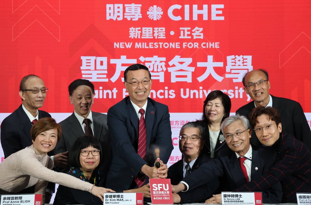 University president Kim Mak (centre) celebrates the change in status for the former college by cracking open a bottle of champagne. Photo: Jelly Tse University president Kim Mak (centre) celebrates the change in status for the former college by cracking open a bottle of champagne. Photo: Jelly Tse