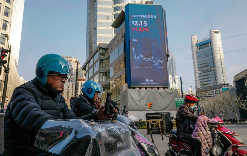 People ride scooters beneath a large screen showing the latest stock exchange data in Shanghai on January 2, 2024. China’s stock market is off to a slow start in 2024. Photo: EPA-EFE People ride scooters beneath a large screen showing the latest stock exchange data in Shanghai on January 2, 2024. China’s stock market is off to a slow start in 2024. Photo: EPA-EFE