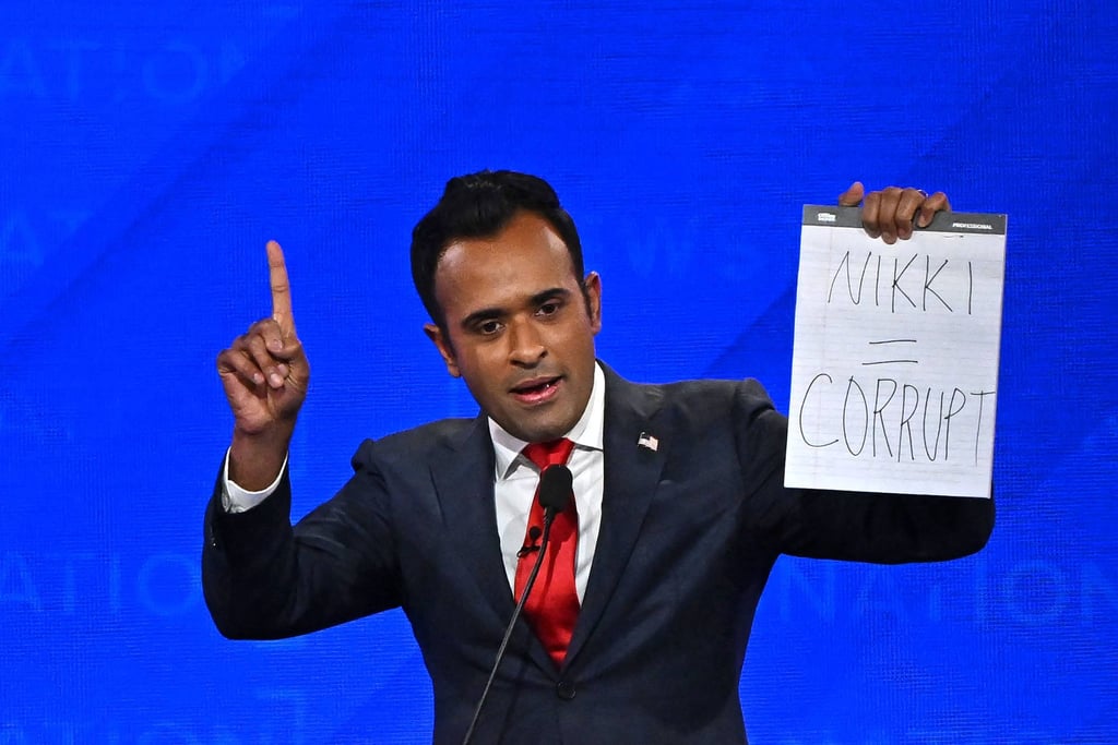 Vivek Ramaswamy holds up a sign reading ‘Nikki = corrupt’ referring to former UN ambassador Nikki Haley, at a debate in December. Photo: AFP Vivek Ramaswamy holds up a sign reading ‘Nikki = corrupt’ referring to former UN ambassador Nikki Haley, at a debate in December. Photo: AFP