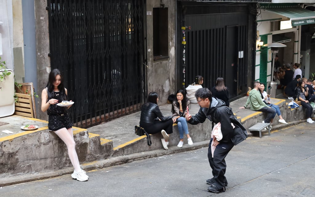 A young woman poses for a pic as she eats on steps on Peel Street in Central. Photo: Wynna Wong A young woman poses for a pic as she eats on steps on Peel Street in Central. Photo: Wynna Wong