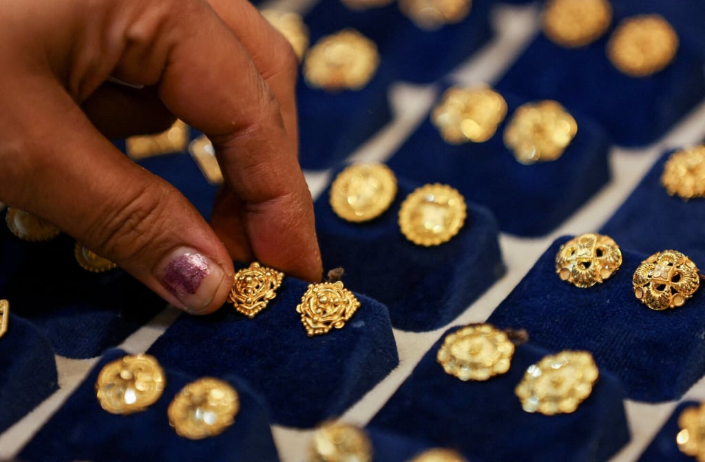A woman picks a gold earring at a jewellery shop in India. The country is traditionally one of the largest buyers of gold. Photo: Reuters