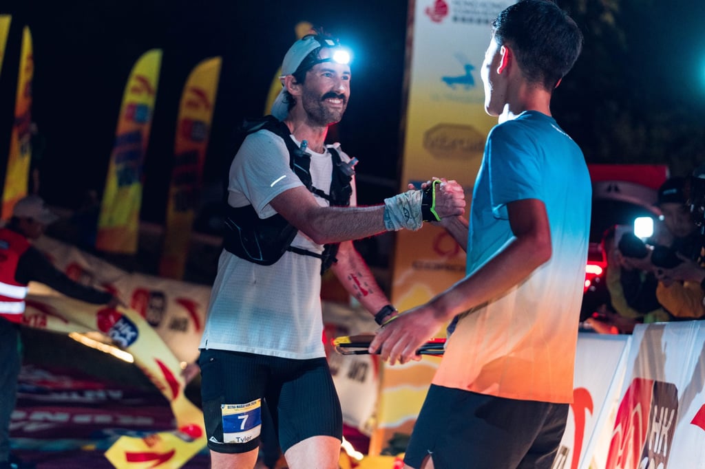 HK100 winner Meng Guangfu (right) congratulates third-placed Tyler Green after he crossed the finish line. Photo: Anta Brand HK100 winner Meng Guangfu (right) congratulates third-placed Tyler Green after he crossed the finish line. Photo: Anta Brand