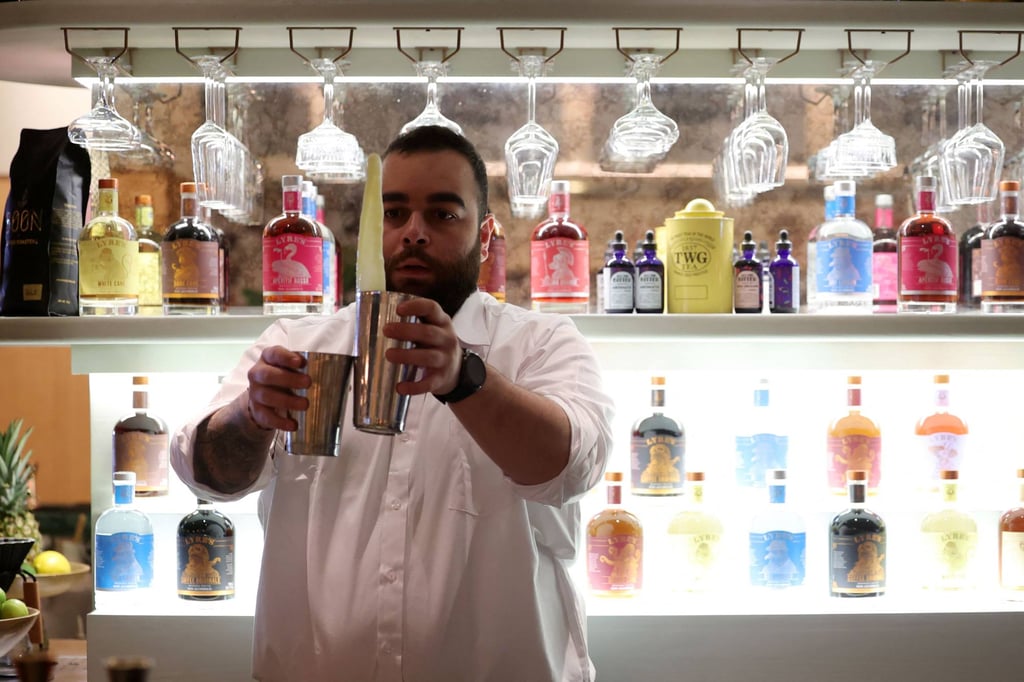 Lebanese bartender Hadi Ghassan prepares a drink behind the counter at a pop-up bar offering non-alcoholic Bellinis and spritzes. Photo: AFP Lebanese bartender Hadi Ghassan prepares a drink behind the counter at a pop-up bar offering non-alcoholic Bellinis and spritzes. Photo: AFP