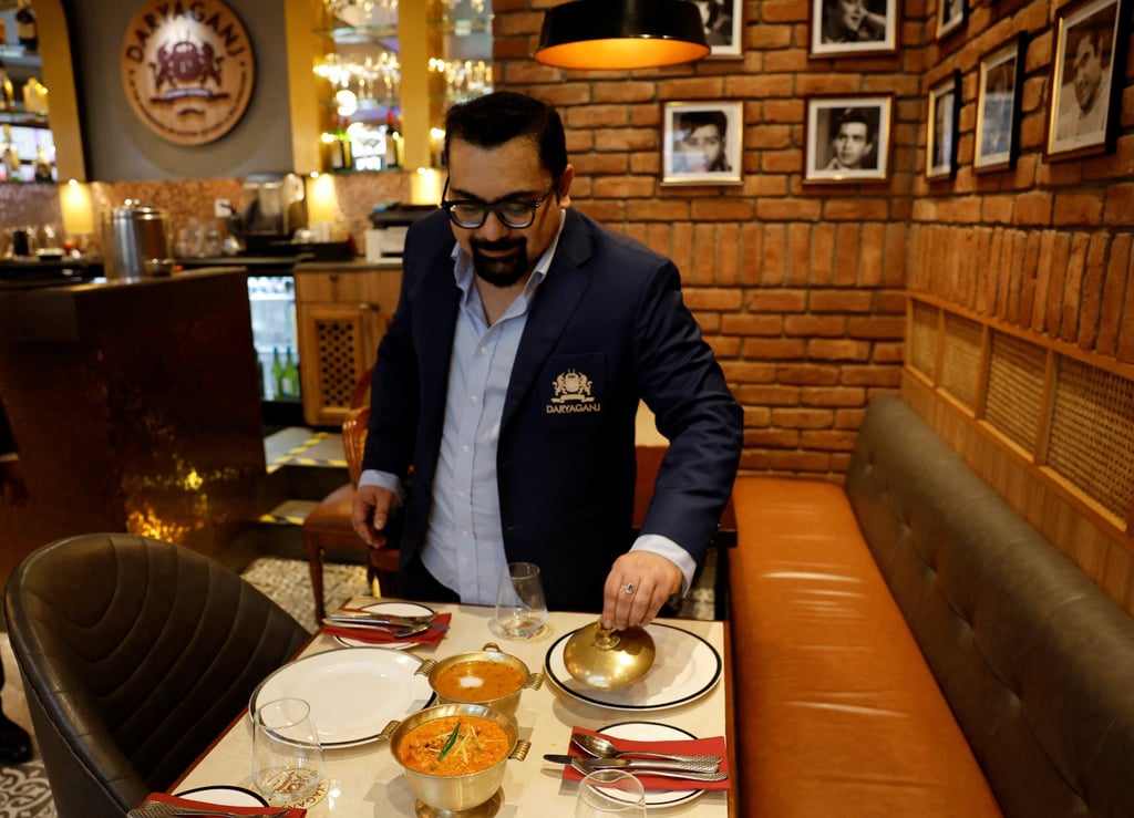 Amit Bagga, CEO of Daryaganj restaurant, shows a freshly prepared butter chicken dish and the lentil dish Dal Makhani inside Daryaganj restaurant in Noida, India. Photo: Reuters
