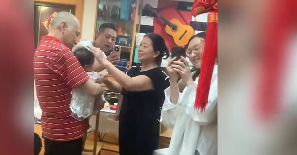 The elderly landlord holds the baby girl as if she is his own granddaughter. Photo: SCMP/Baidu The elderly landlord holds the baby girl as if she is his own granddaughter. Photo: SCMP/Baidu