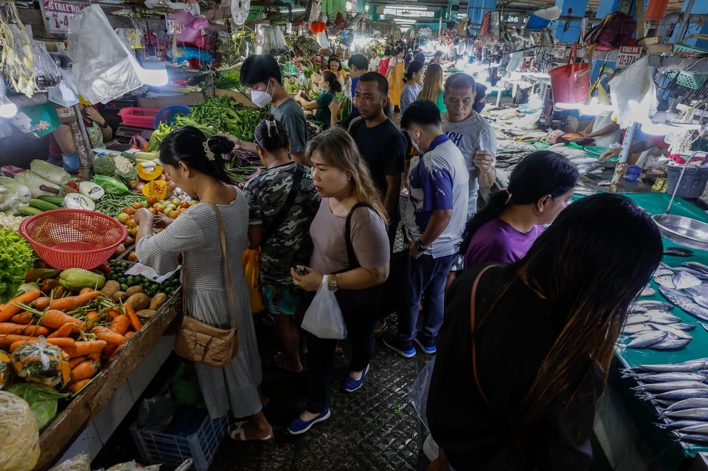 Customers buy food items at a market in Quezon City, Metro Manila. Photo: EPA-EFE