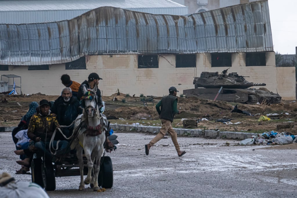 An Israeli army tank takes up position as Palestinians arrive in the southern Gaza town of Rafah after fleeing Khan Younis. Photo: AP An Israeli army tank takes up position as Palestinians arrive in the southern Gaza town of Rafah after fleeing Khan Younis. Photo: AP