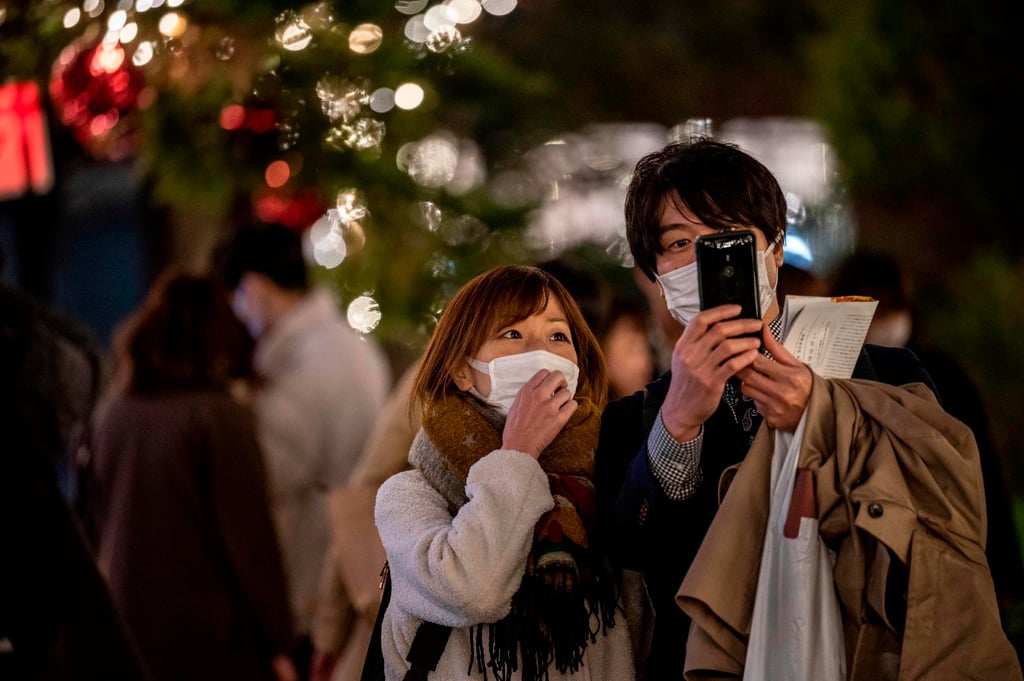 A couple takes pictures of Christmas-themed illuminated trees in Tokyo on December 24, 2020. Photo: AFP A couple takes pictures of Christmas-themed illuminated trees in Tokyo on December 24, 2020. Photo: AFP