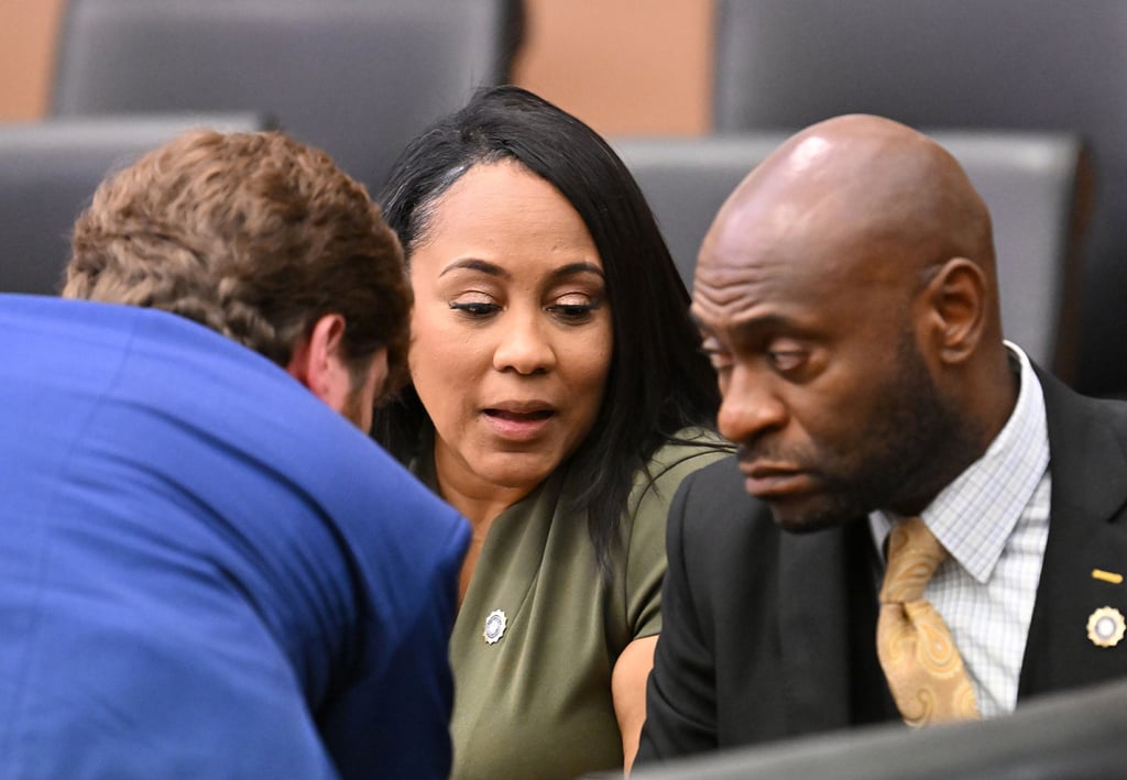 Fulton County District Attorney Fani Willis (centre) speaks with lead prosecutors Donald Wakeford (left) and Nathan Wade, during a motion hearing at Fulton County Courthouse in Atlanta in July 2022. Photo: TNS