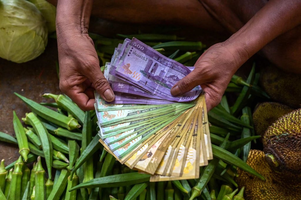 A vendor holds Sri Lankan cash at a market in Colombo. Photo: AFP A vendor holds Sri Lankan cash at a market in Colombo. Photo: AFP