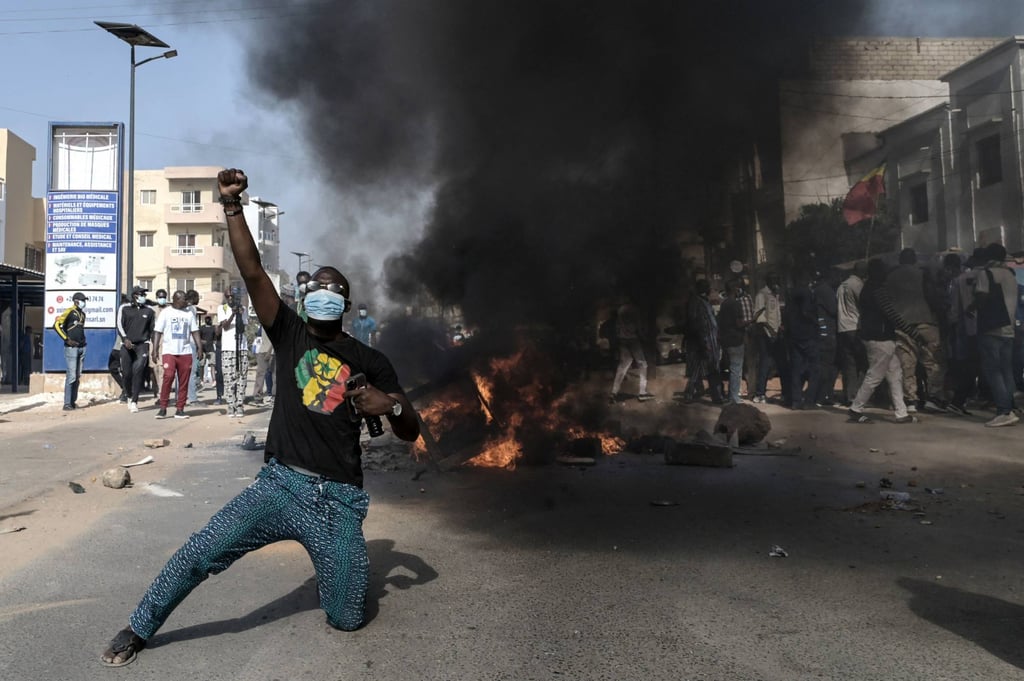 An opposition supporter in front of a burning barricade during protests in Dakar, Senegal on Sunday. Photo: AFP An opposition supporter in front of a burning barricade during protests in Dakar, Senegal on Sunday. Photo: AFP