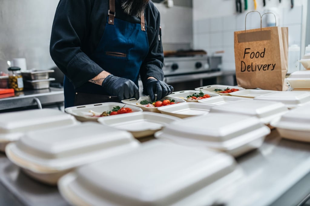 Food is placed into disposable lunchboxes at a restaurant. Photo: Shutterstock