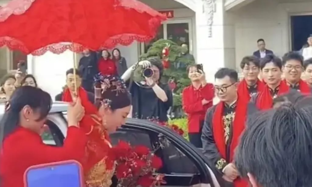 The bride is ushered into the extravagantly decorated venue under an auspicious red umbrella. Photo: Douyin The bride is ushered into the extravagantly decorated venue under an auspicious red umbrella. Photo: Douyin