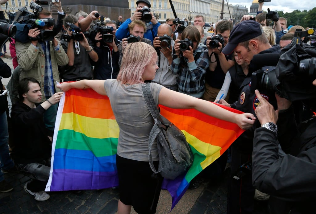 An activist stands with a rainbow flag in front of journalists during a protest in St Petersburg, Russia. Photo: AP An activist stands with a rainbow flag in front of journalists during a protest in St Petersburg, Russia. Photo: AP
