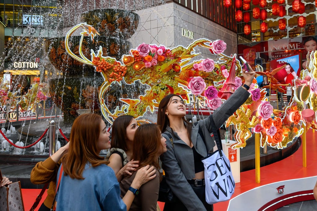 Shoppers pose for a selfie with a Lunar New Year-themed installation at a shopping centre in Malaysia last month. Photo: Xinhua Shoppers pose for a selfie with a Lunar New Year-themed installation at a shopping centre in Malaysia last month. Photo: Xinhua