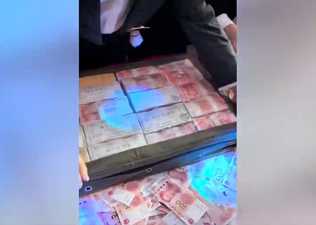 A company employee empties a box full of cash ahead of the year-end bonus money-counting event. Photo: Baidu