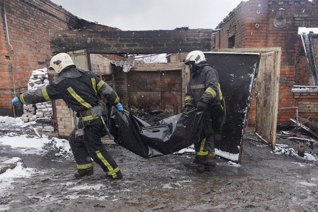 Firefighters carry the body of a resident killed in a fire when a Russian drone hit the city of Kharkiv in Ukraine. Photo: AP