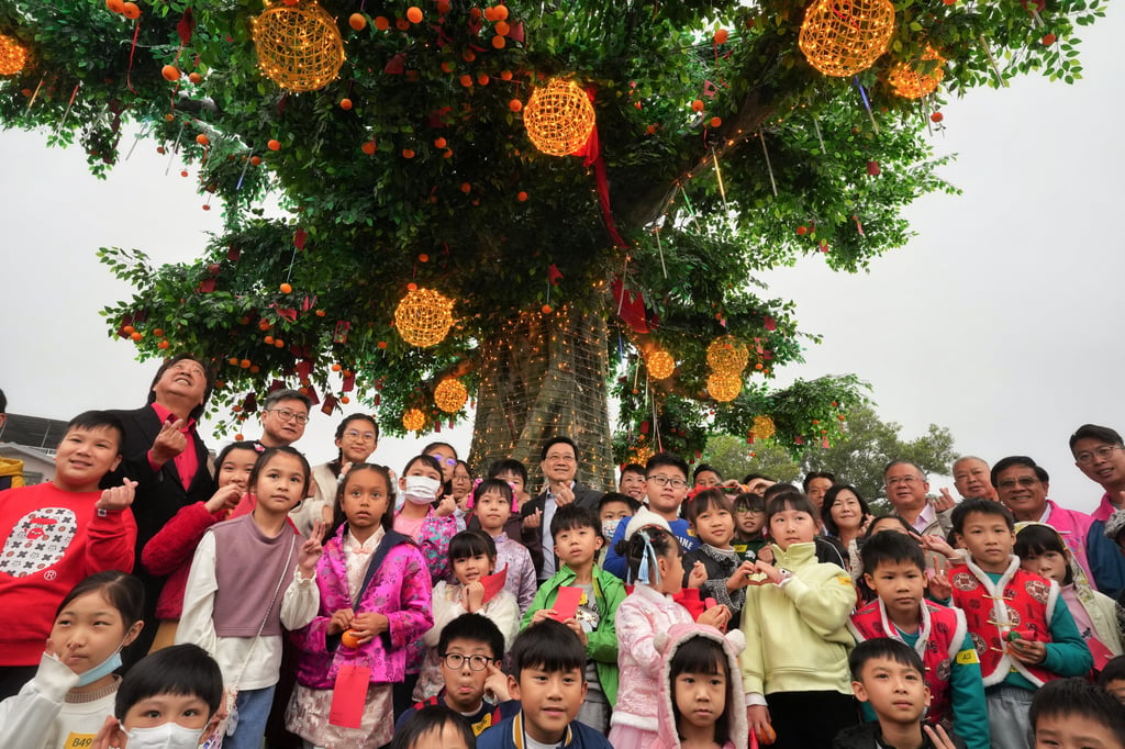 Chief Executive John Lee (centre) takes pictures with children under the Lam Tsuen Wishing Tree. Photo: Elson Li