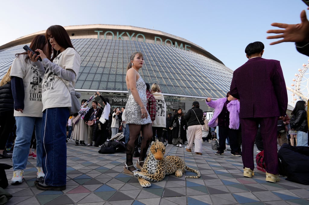 A woman poses for a photo with a stuffed leopard before Taylor Swift’s concert at Tokyo Dome on Saturday. Photo: AP