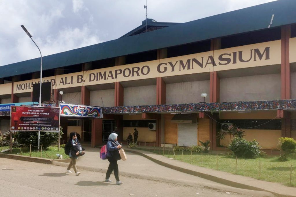 Women walk past the site where a bomb exploded in Marawi. Photo: AP