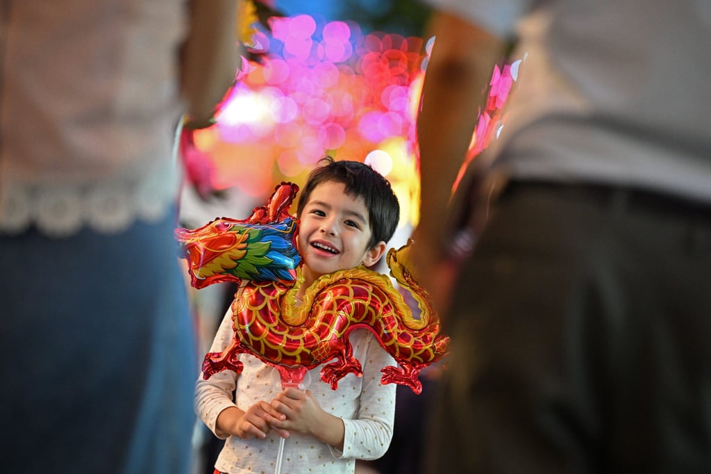 A child poses with a dragon-shaped balloon at a market for Lunar New Year in Singapore. Photo: Xinhua