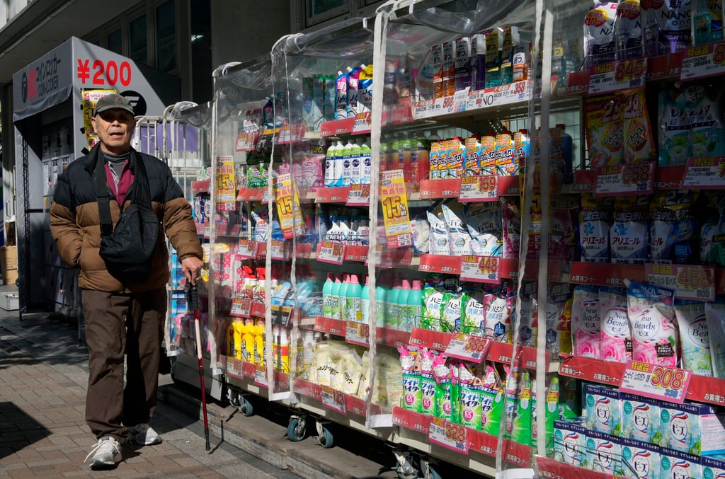 A passer-by walks past a pharmacy in Tokyo. The report came as the BOJ grows more confident about the possibility of its inflation target being achieved in a stable and sustainable manner, accompanied by wage growth. Photo: EPA-EFE