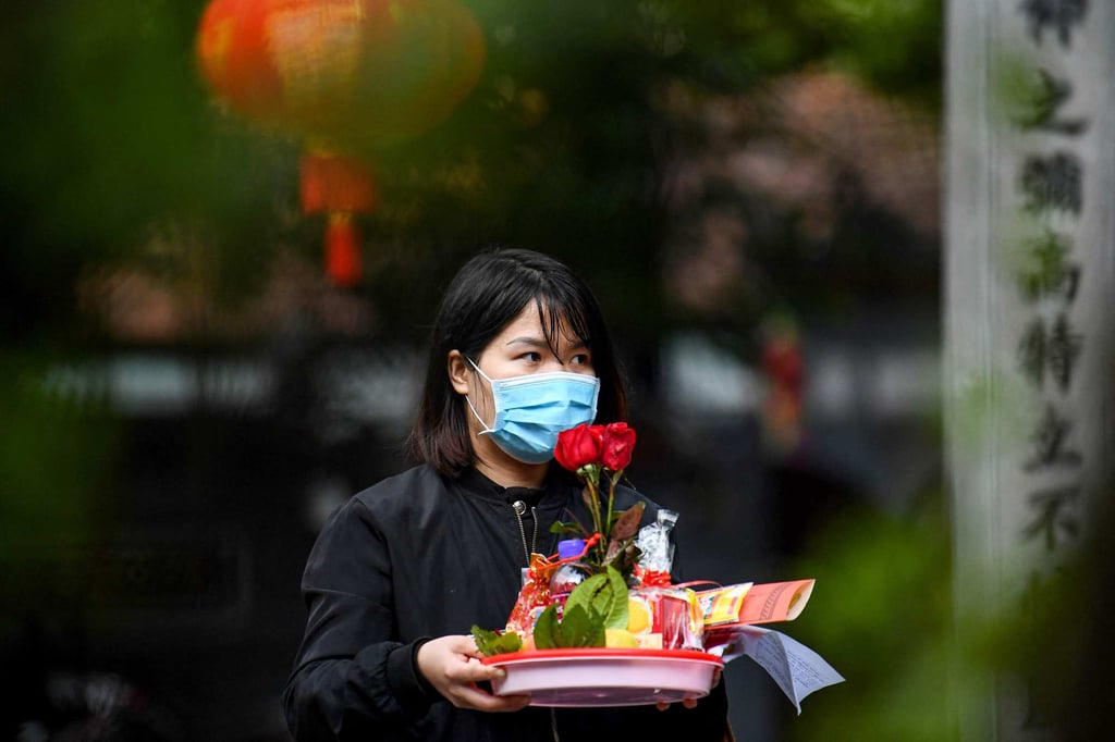 A woman holds a tray of offerings to pray to find love on Valentine’s Day at Ha Pagoda in Hanoi on February 14. Photo: AFP