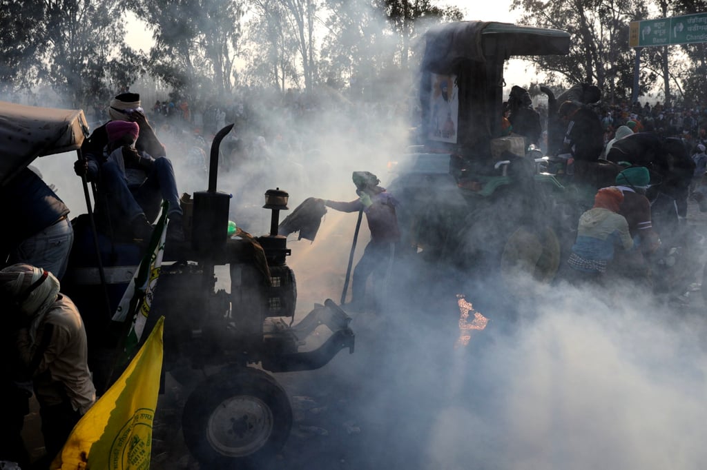 Protesters stand by their vehicles amid teargas fired by Indian police. Photo: EPA-EFE Protesters stand by their vehicles amid teargas fired by Indian police. Photo: EPA-EFE