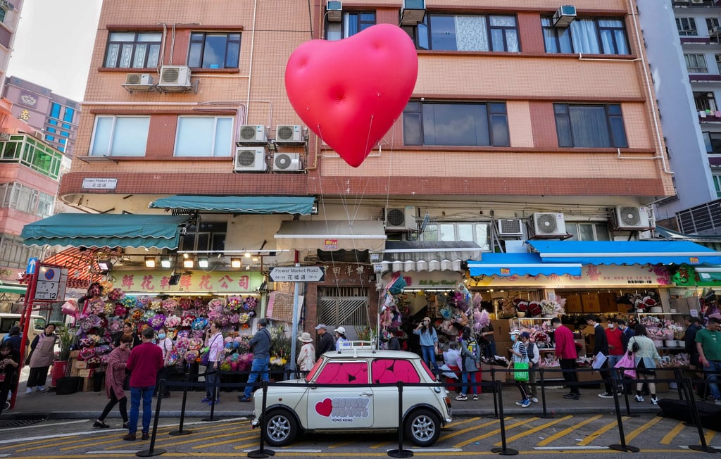 A pop-up “Chubby Hearts” balloon art installation by British fashion designer Anya Hindmarch attached to a classic Mini car floats over Flower Street in Mong Kok. Photo: Elson Li A pop-up “Chubby Hearts” balloon art installation by British fashion designer Anya Hindmarch attached to a classic Mini car floats over Flower Street in Mong Kok. Photo: Elson Li