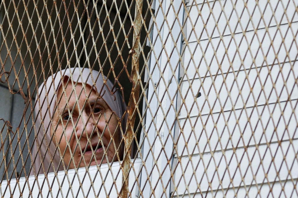 A Palestinian woman looks through a window during an Israeli raid at Tulkarm, in the Israeli-occupied West Bank. Photo: Reuters