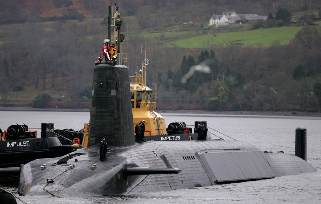 Crew from HMS Vengeance, a British Royal Navy Vanguard class Trident Ballistic Missile Submarine, stand on their vessel as they return along the Clyde river to the Faslane naval base near Glasgow, Scotland, in December 2006. Photo: Reuters