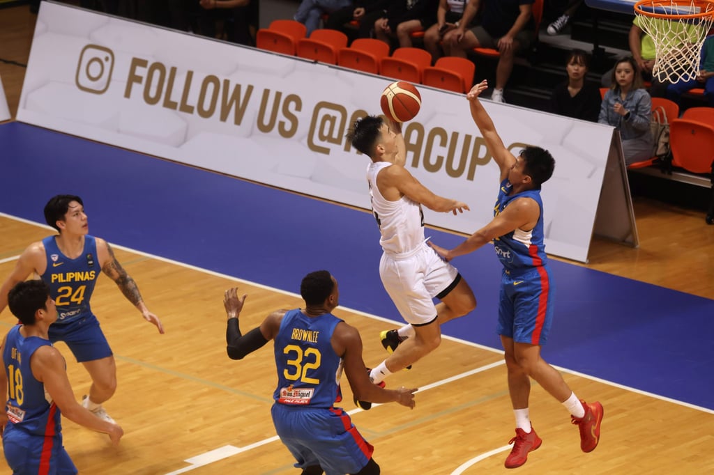 Hong Kong’s Oliver Xu (in white) shoots as Justin Brownlee and Scottie Thompson try to block. Photo: Jonathan Wong