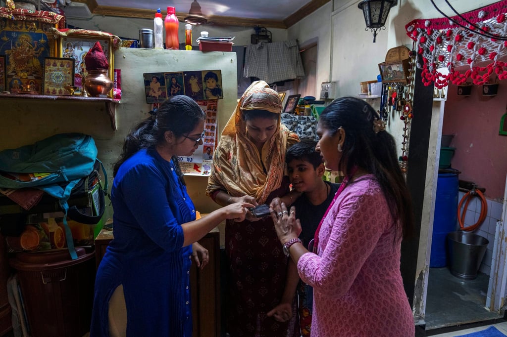 Tanvi Divate (left), co-founder and research manager of Myna Mahila Foundation, teaches Komal Vilas Thatkare (middle) to use the chatbot. Photo: AP Tanvi Divate (left), co-founder and research manager of Myna Mahila Foundation, teaches Komal Vilas Thatkare (middle) to use the chatbot. Photo: AP