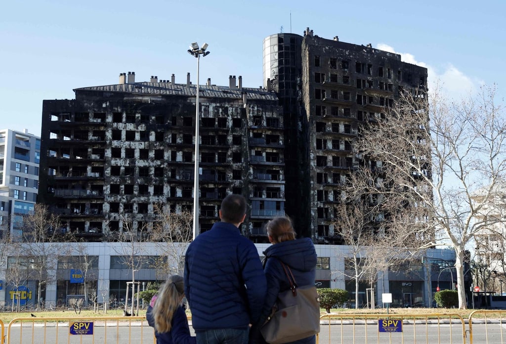 Pedestrians observe a burnt residential block two days after a huge fire killed 10 people, in Valencia. Photo: AFP Pedestrians observe a burnt residential block two days after a huge fire killed 10 people, in Valencia. Photo: AFP