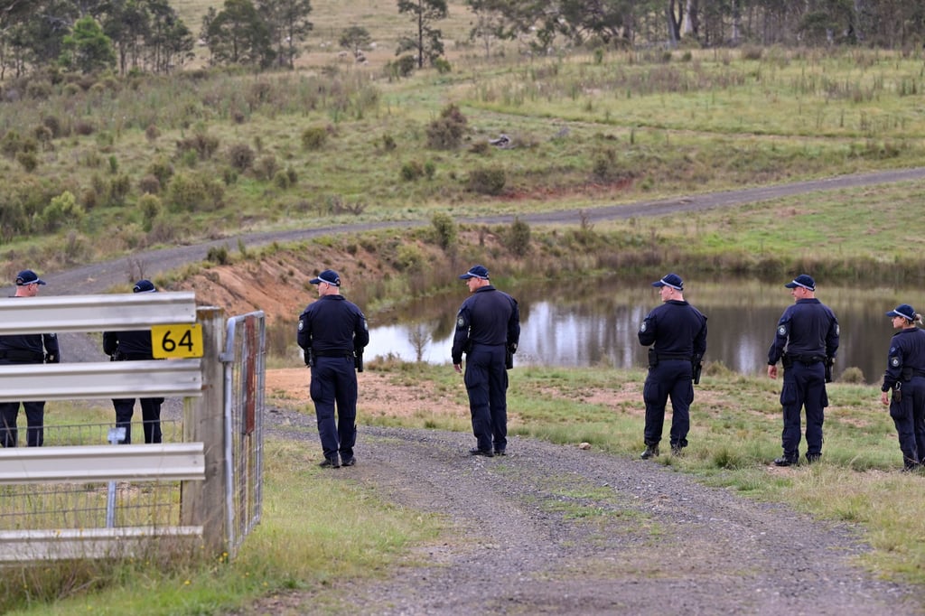 Police conduct a line search near a body of water on a rural property near Bungonia, 170km southwest of Sydney. Divers searched inland waterways on Monday for the bodies of a same-sex couple allegedly shot dead in Sydney a week earlier by a jilted police officer lover with his service pistol. Photo: AP