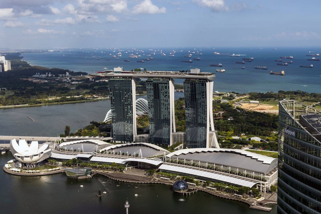 Container ships and bulk carriers behind the Marina Bay Sands hotel and casino. The hotel’s S$50,000 (US$37,230) “Wildest Dreams” package – which includes VIP tickets, fine dining, a hotel suite, limousine transfers and passes to tourist attractions – were sold out. Photo: Bloomberg
