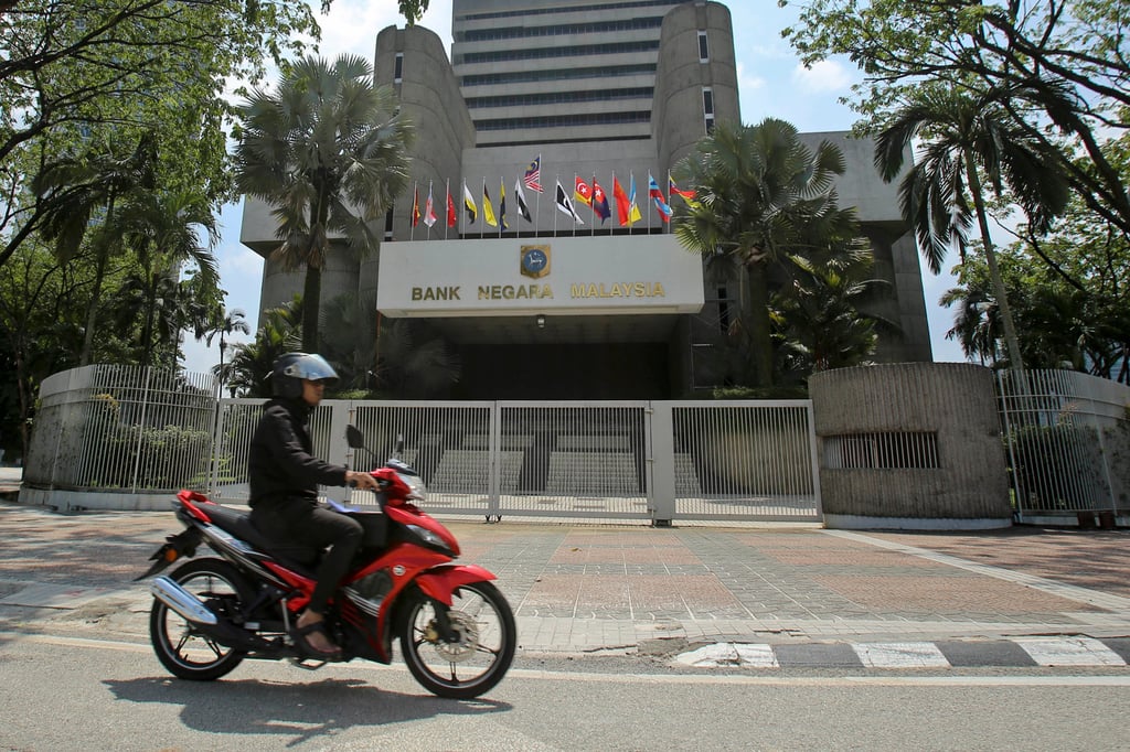 A motorcyclist rides past Malaysia’s central bank building in Kuala Lumpur on June 6, 2018. Photo: AP